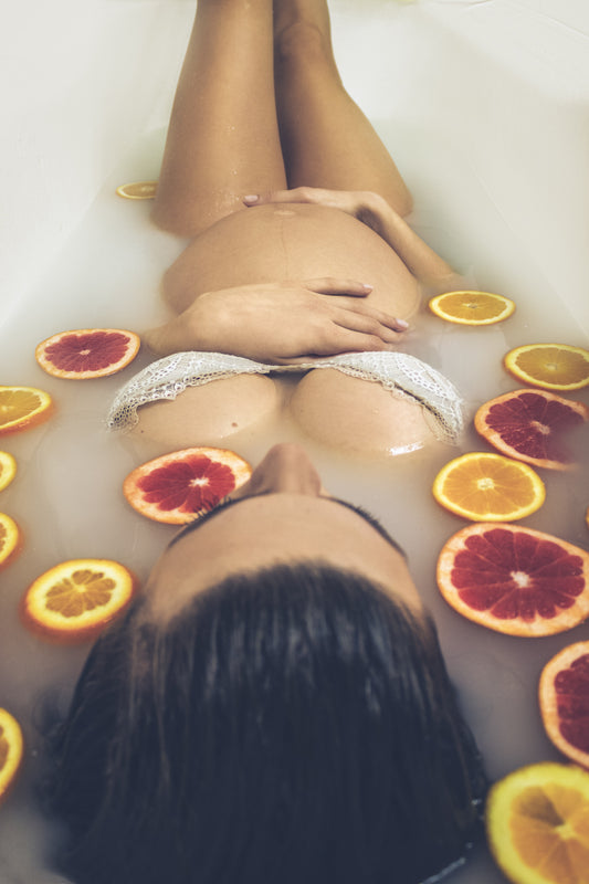 pregnant belly dipped in a bath with citrus